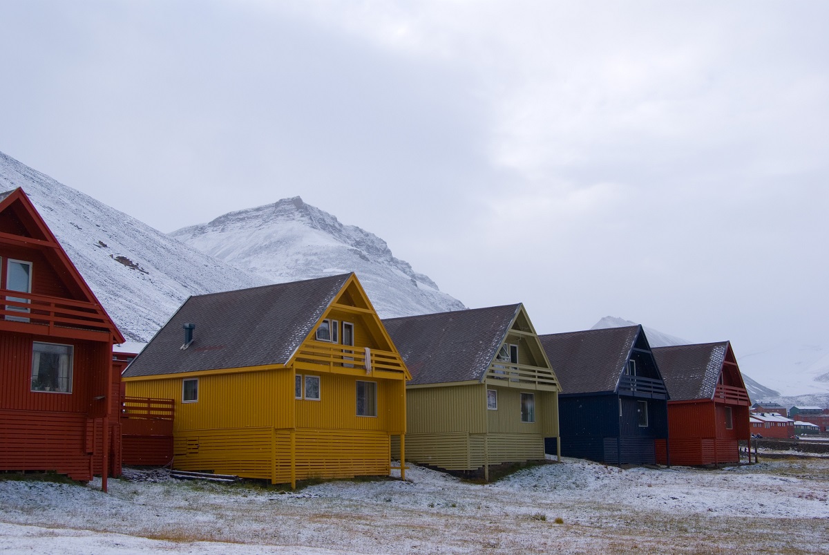 Rij gekleurde huizen in Longyearbyen op Spitsbergen met een dun laagje sneeuw.