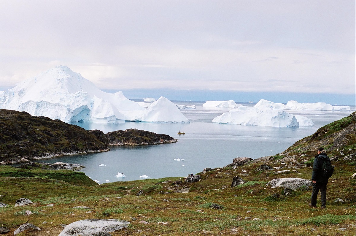 Een reiziger kijkt in Sermermiut Groenland naar de enorme ijsbegren die in de fjord voorbij drijven.