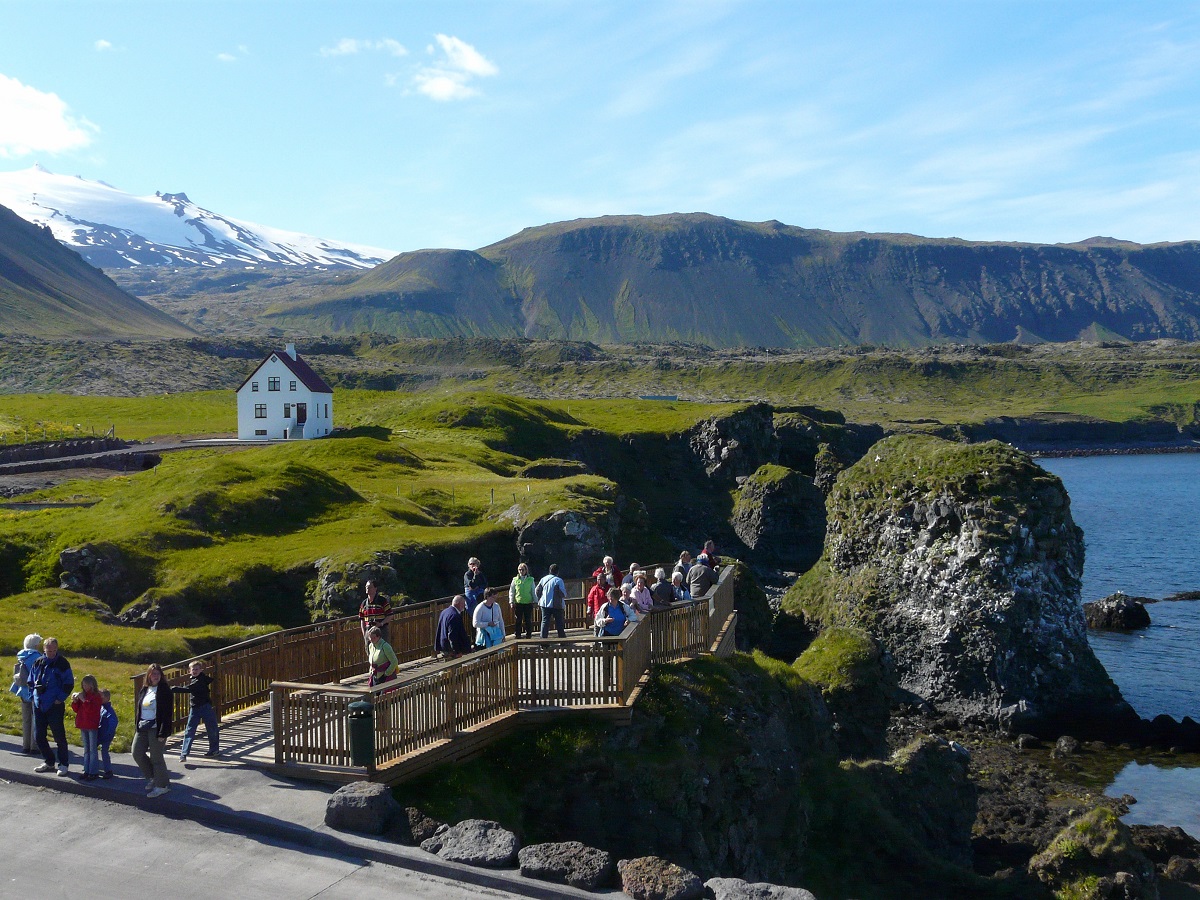 Reizigers op de boardwalk bij de kliffen van Arnarstapi, West IJsland.