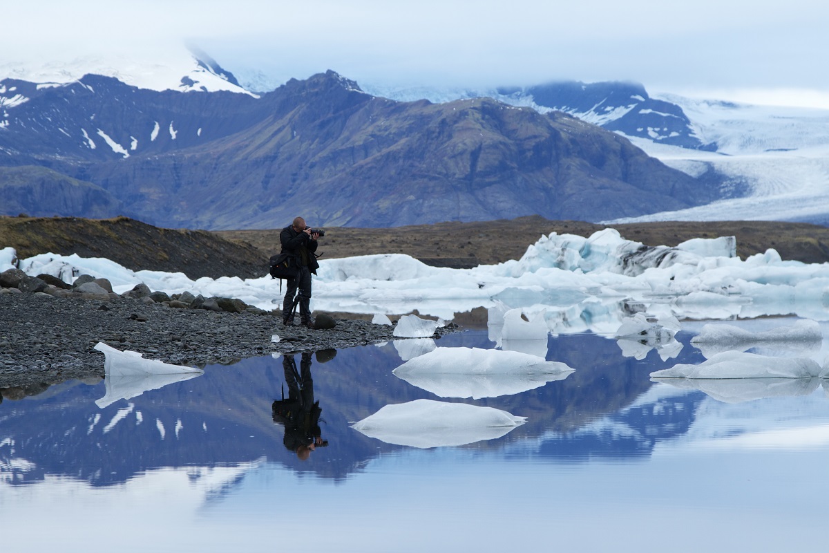 Een deelnemer van de fotoreis van FotoClass fotografeert ijsschotsen in Jokulsarlon op IJsland.