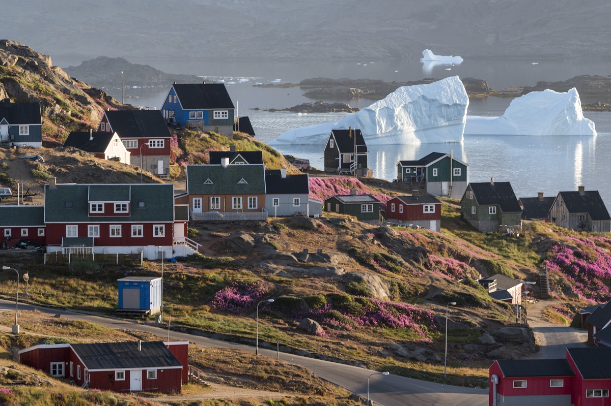 IJsbergen drijven langs het kleurrijke dorpje Tasiilaq in Oost Groenland.