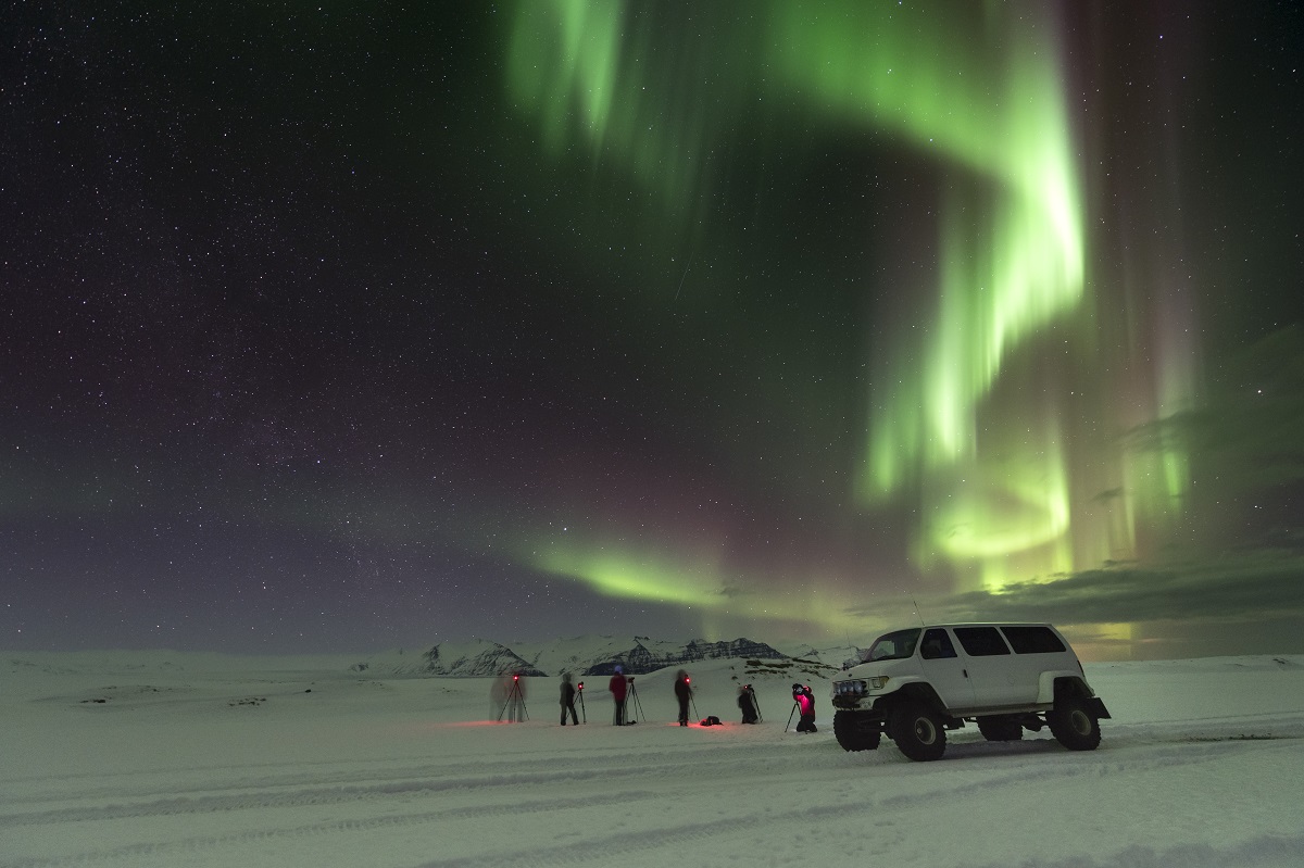Fotografen tijdens een groepsreis met superjeep bewonderen de aurora borealis, ofwel het magische noorderlicht.