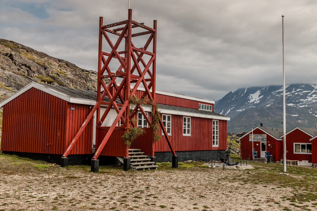Een feestelijk opgetuigde en rood geschilderde kerk in Tasiusaq, Zuid Groenland.
