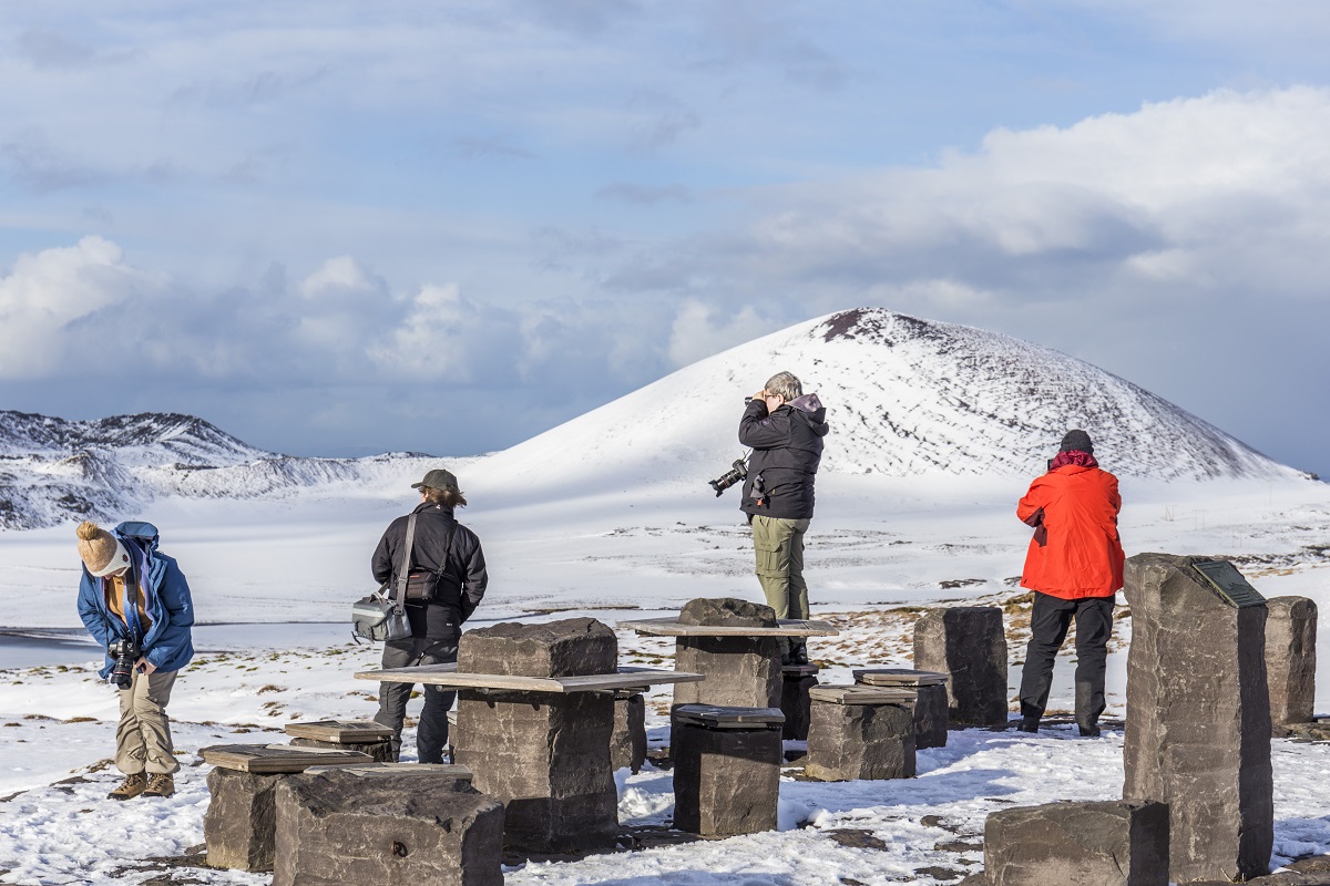 Reizigers fotograferen tijdens een groepsreis met FotoClass het winterse IJslandse landschap.
