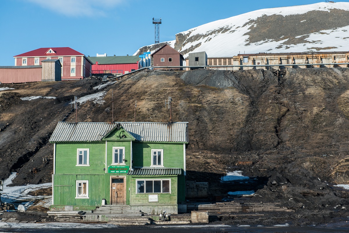 Het groene gebouw is het havenkantoor in Barentsburg in Spitsbergen.