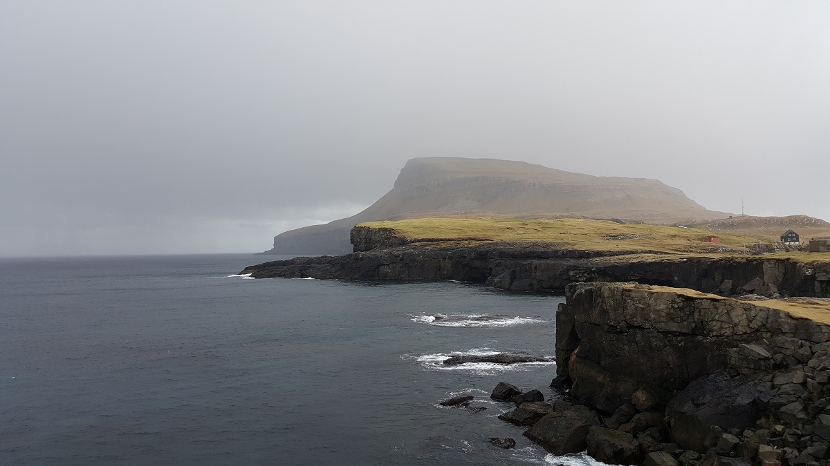 De kliffen van Nolsoy in de mist op de Faroer.