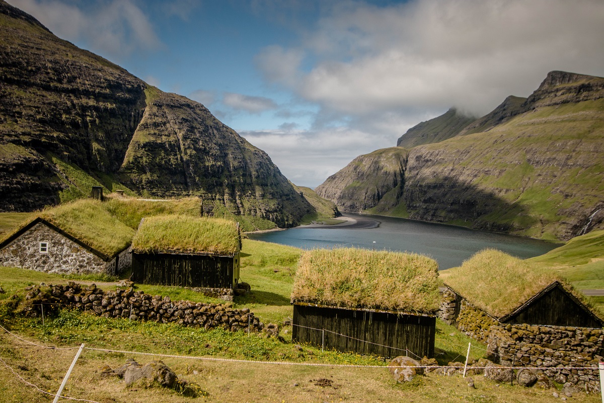 Houten huisjes met grasdaken in Saksun op de Faroer eilanden met uitzicht op de fjord.