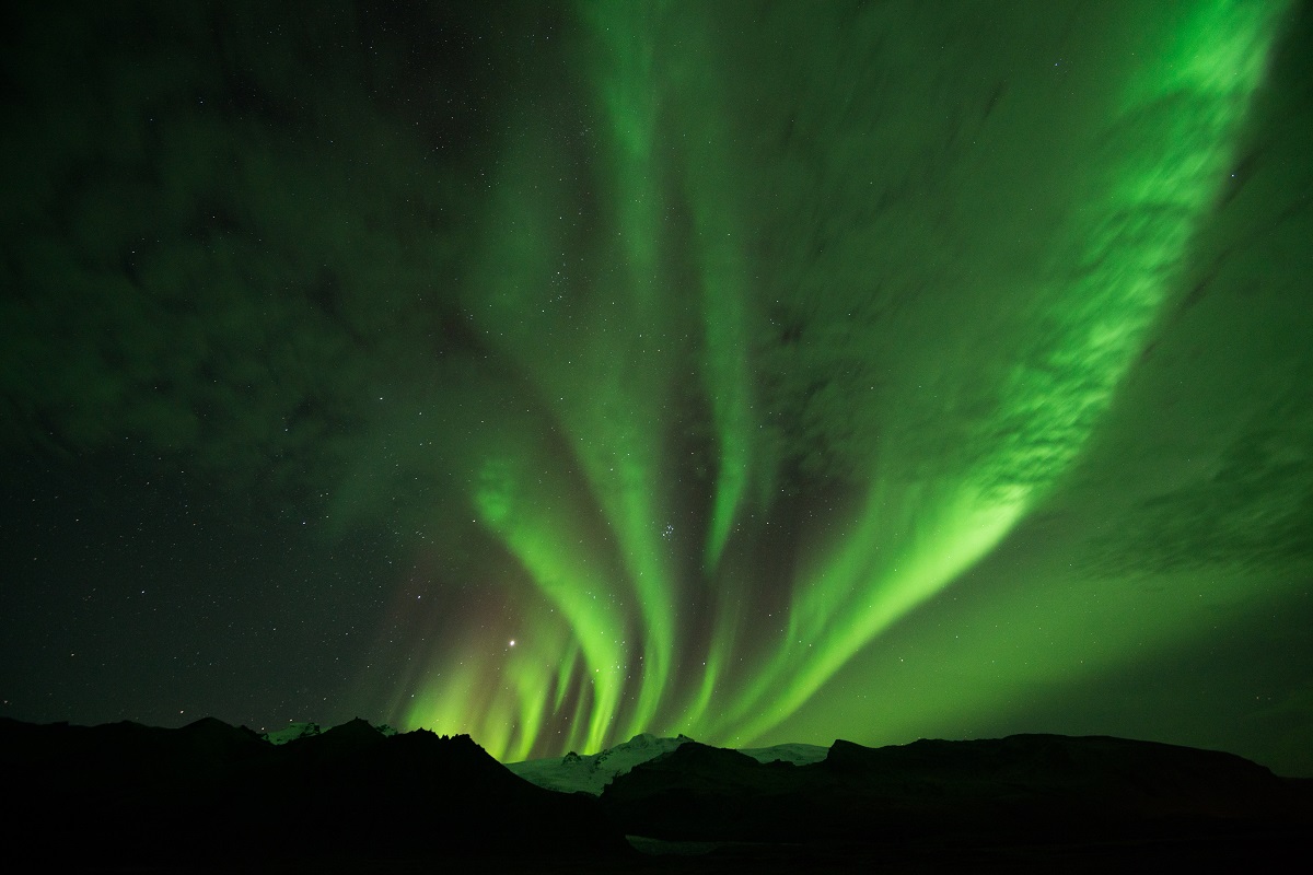 Prachtige groene strepen noorderlicht boven de bergtoppen in IJsland.