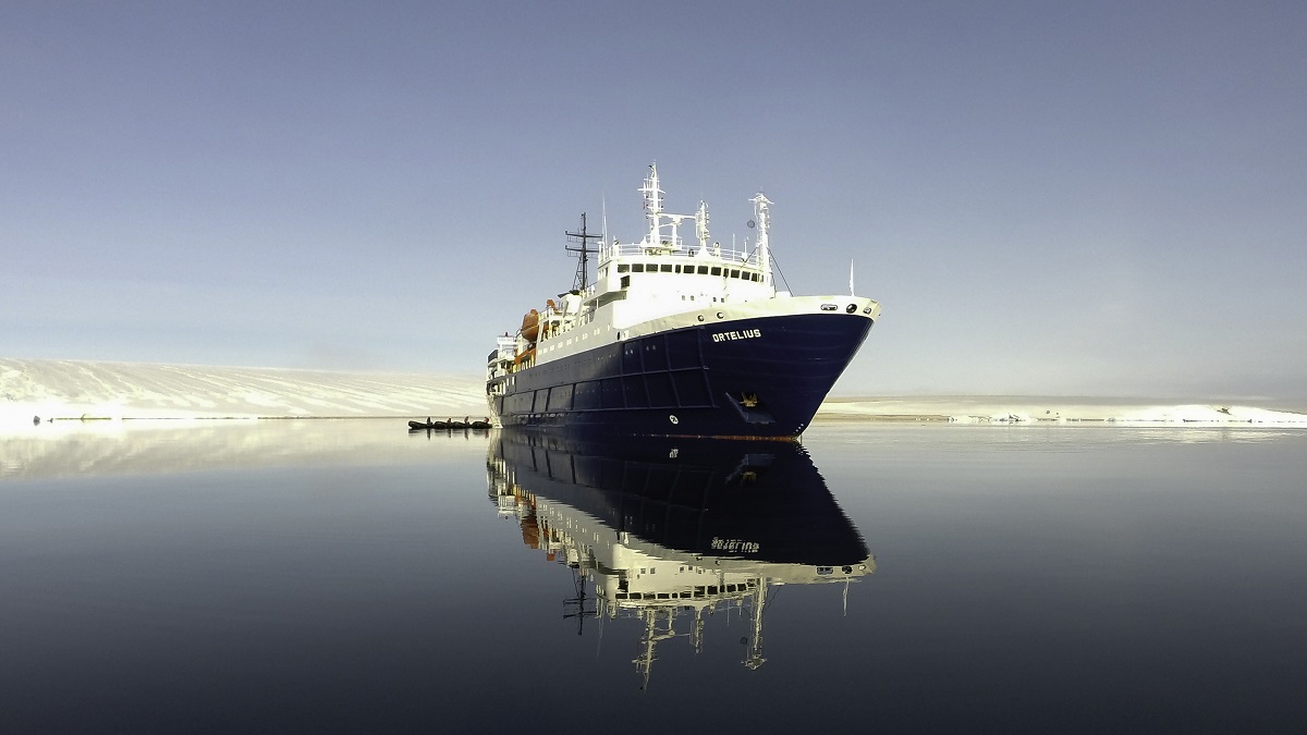 Het cruiseschip Ortelius in Spitsbergen weerspiegelt in het stille water.