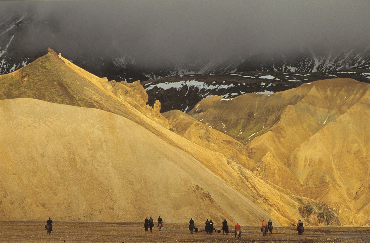 Paardrijden in Landmannalaugar, de hooglanden van IJsland, door een landschap met oranje bergen.
