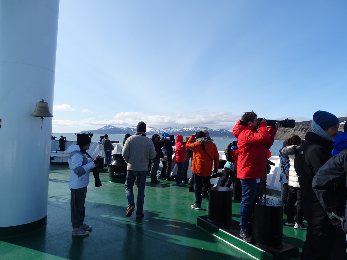 Reizigers fotograferen vanaf het dek van het expeditie cruiseschip de Hondius in Spitsbergen.