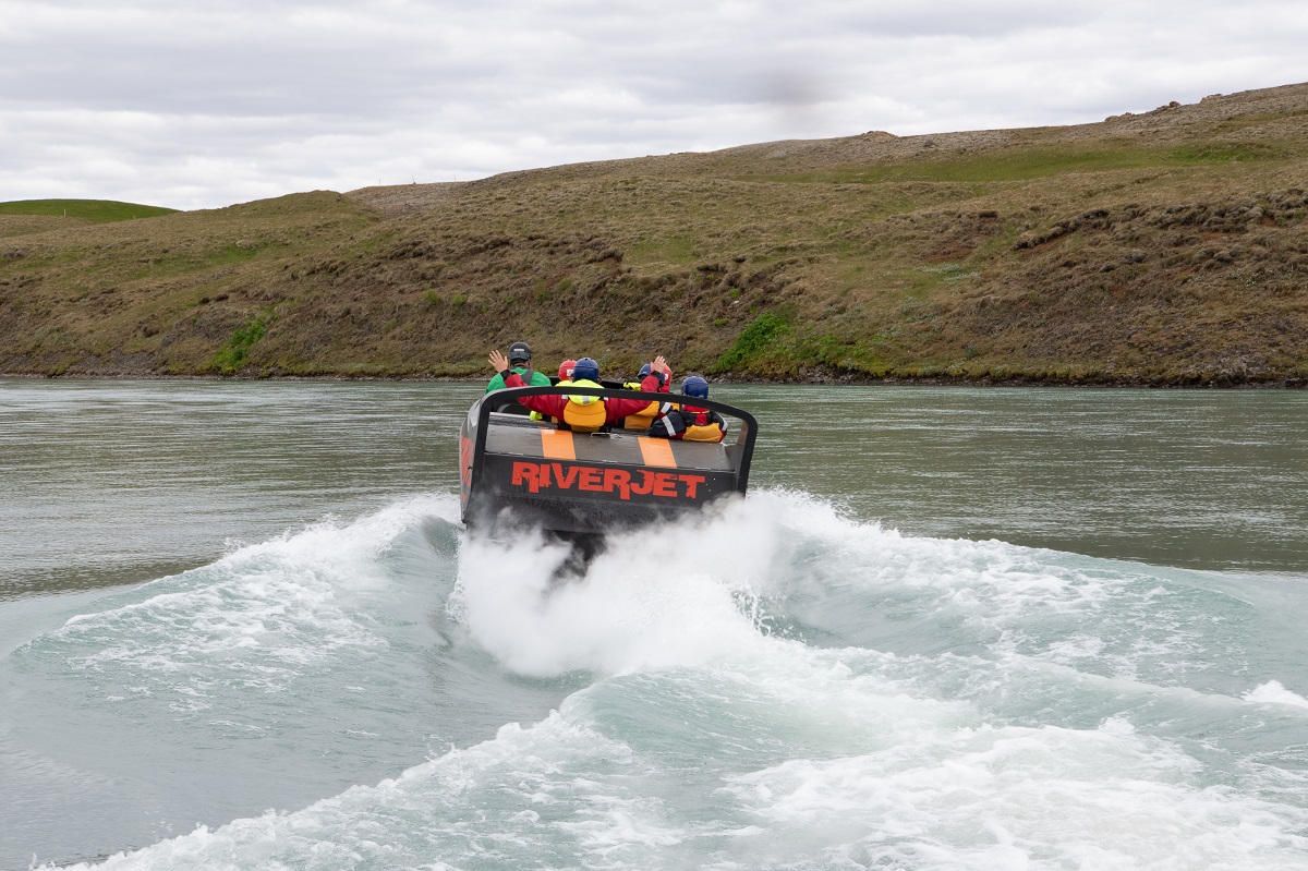 Een riverjet speedboot met toeristen in actie in de rivier Hvita in zuid IJsland.