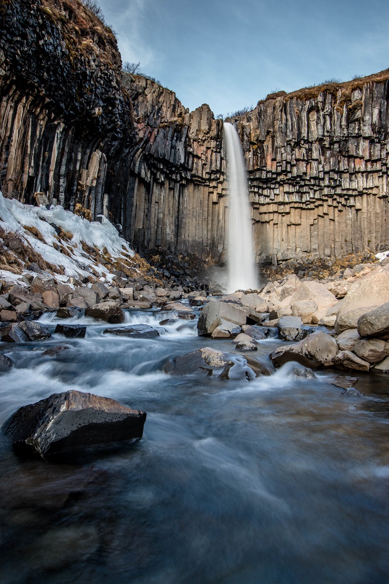 De Svartifoss waterval, in Skaftafell, omgeven door basaltkolommen in een winters landschap.