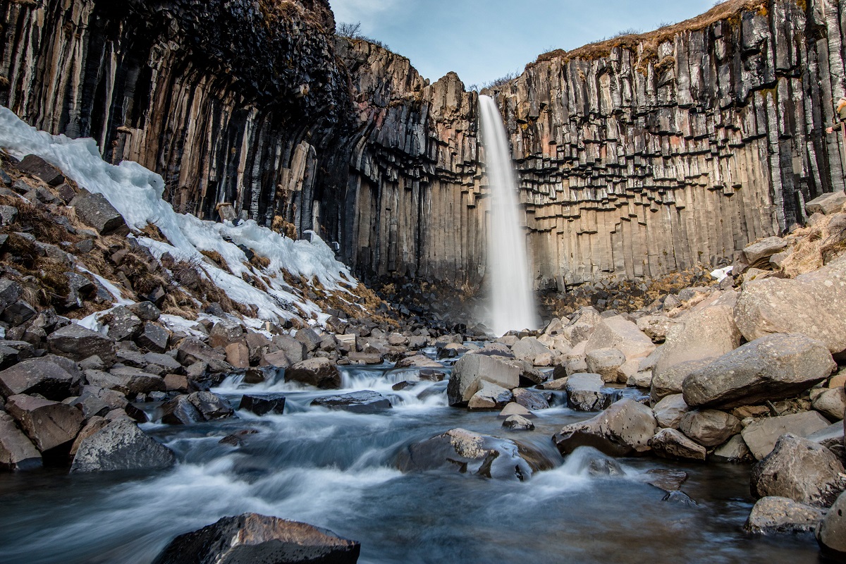 De Svartifoss waterval in Skaftafell valt tussen de basaltkolommen in een winters landschap.