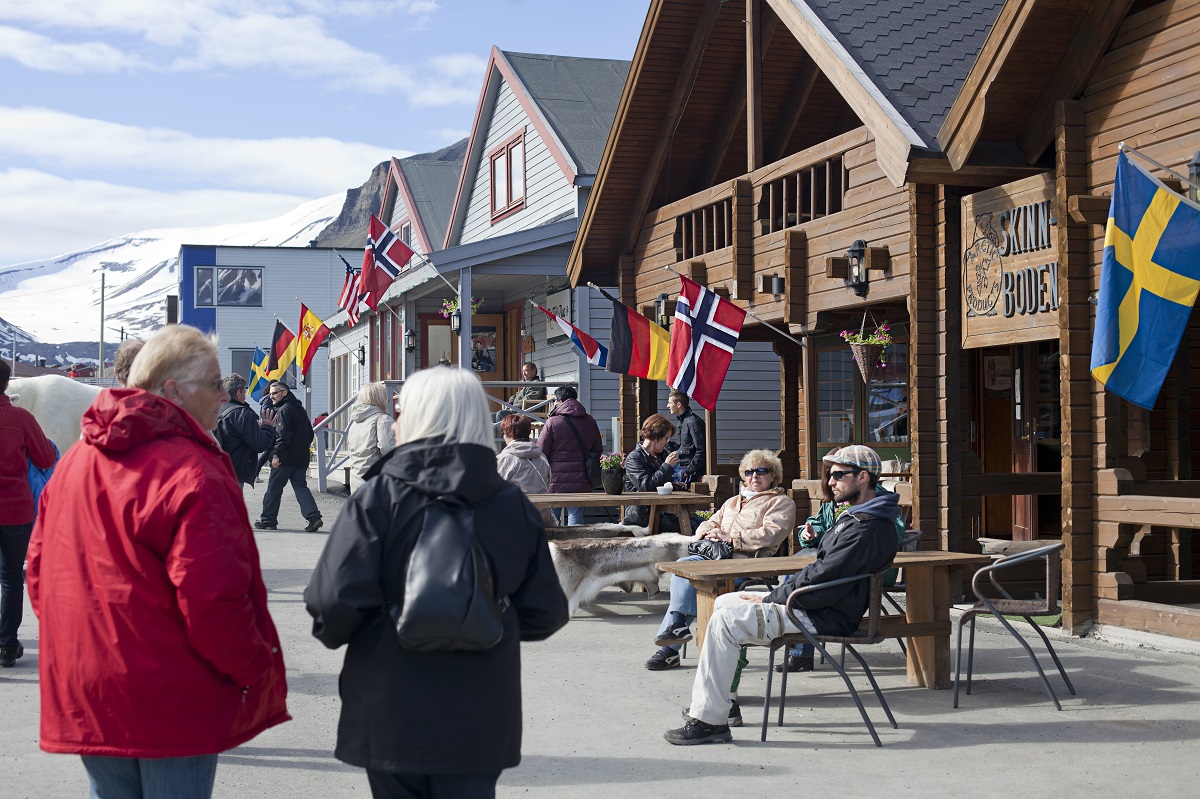 Mensen genieten op het terras in het centrum van Longyearbyen, Spitsbergen.