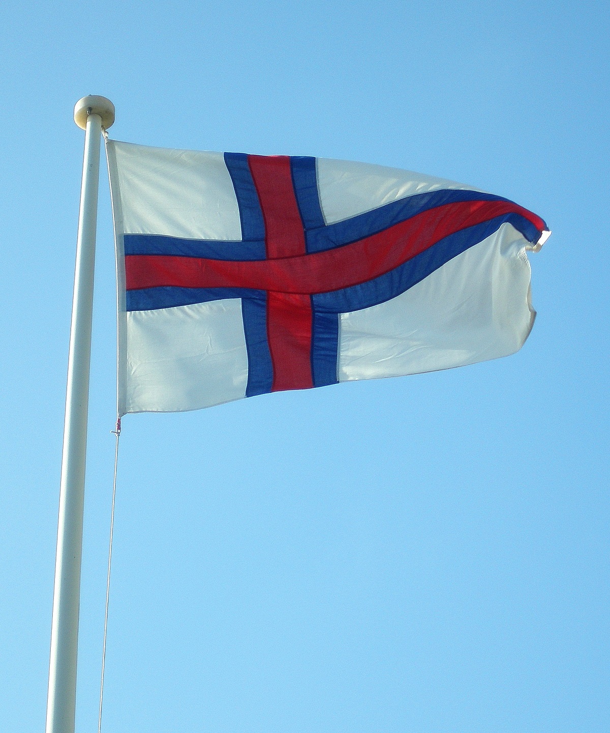 Wapperende vlag op de Faroer met een strak blauwe lucht.