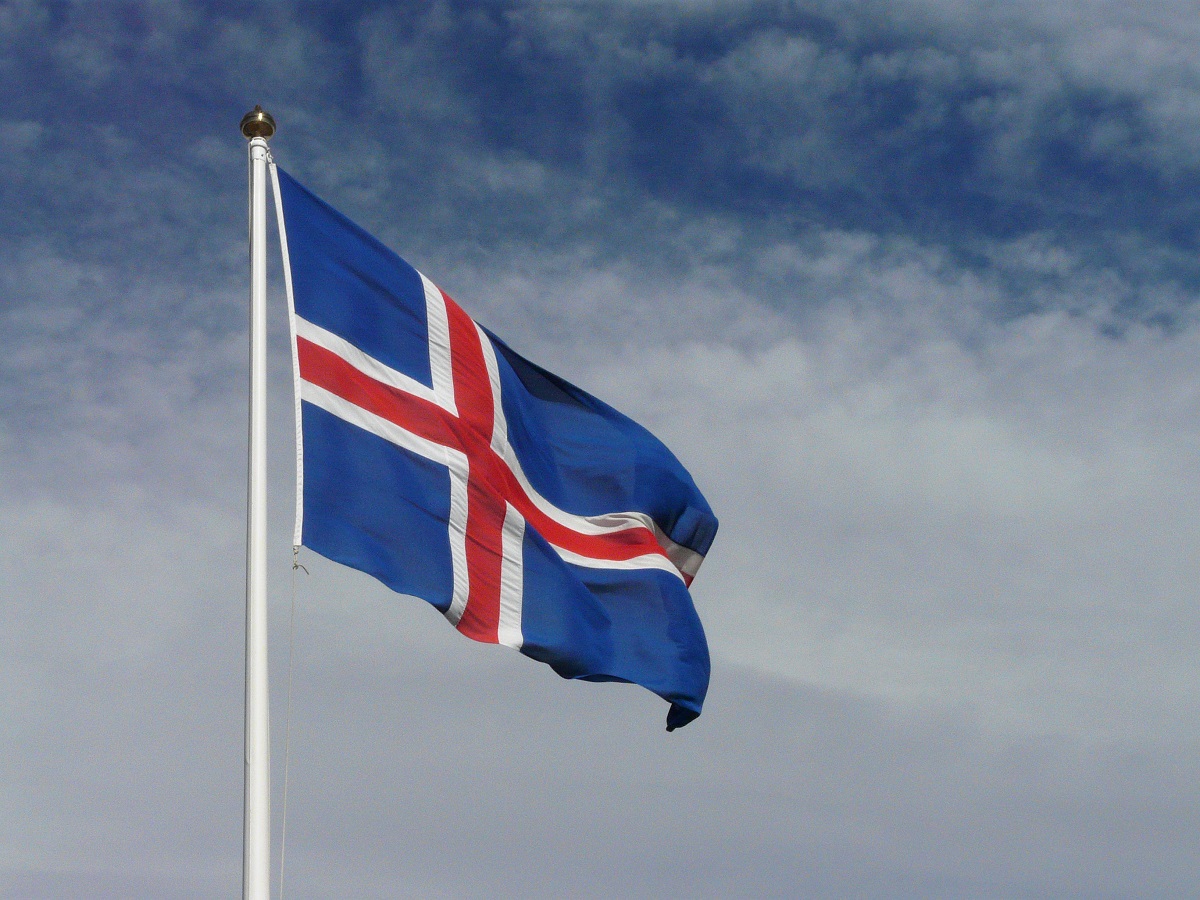 Wapperende IJslandse vlag blauw met rood kruis.