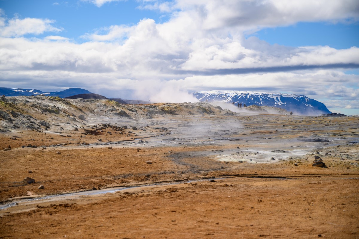 In het geothermische gebied Namaskard vliegen stoompluimen richting de bewolkte lucht.