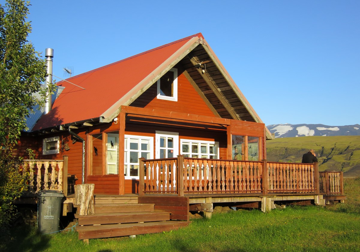 Een houten vakantiewoning, in het privé bezit van IJslanders, met veranda in zuid IJsland.