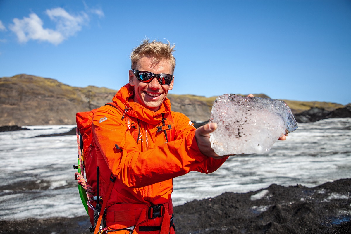 De gids van icelandic Mountain Guides heeft een blok gletsjerijs in zijn hand.
