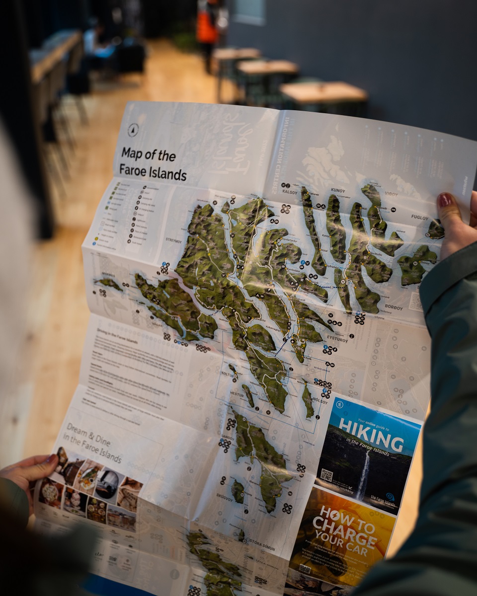 Een reiziger houd de kaart van de Faroer vast.