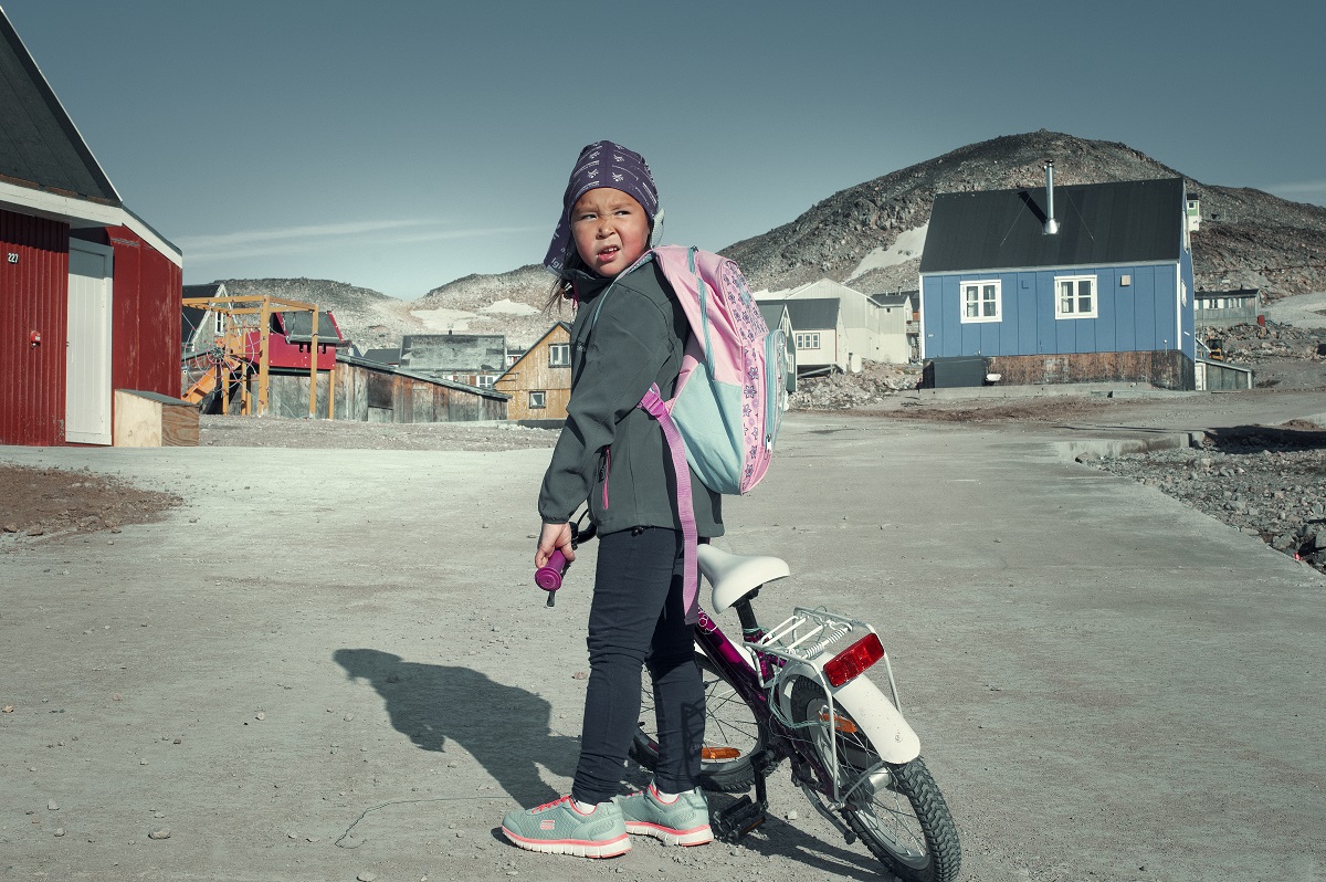 Meisje op de fiets in het dorpje Ittoqqortoormitt.