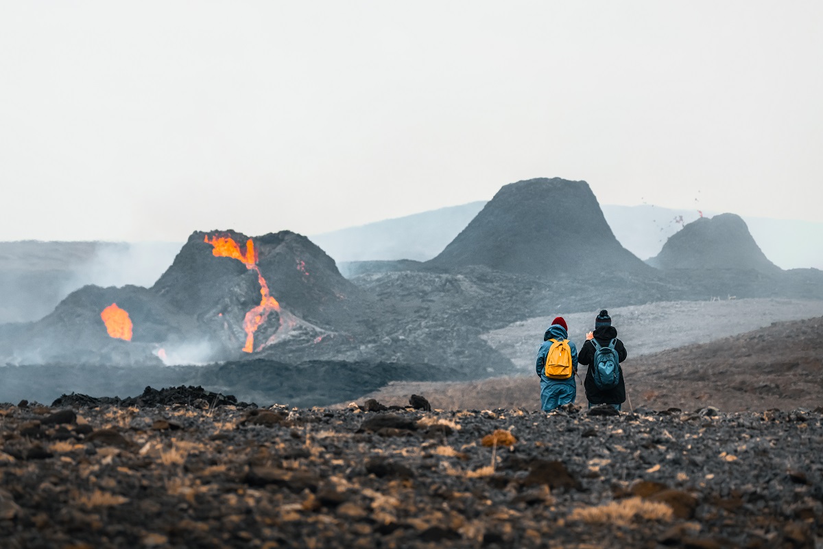 Twee mensen kijken naar de uitbarsting van vulkaan Geldingardalir in Reykjanes IJsland.